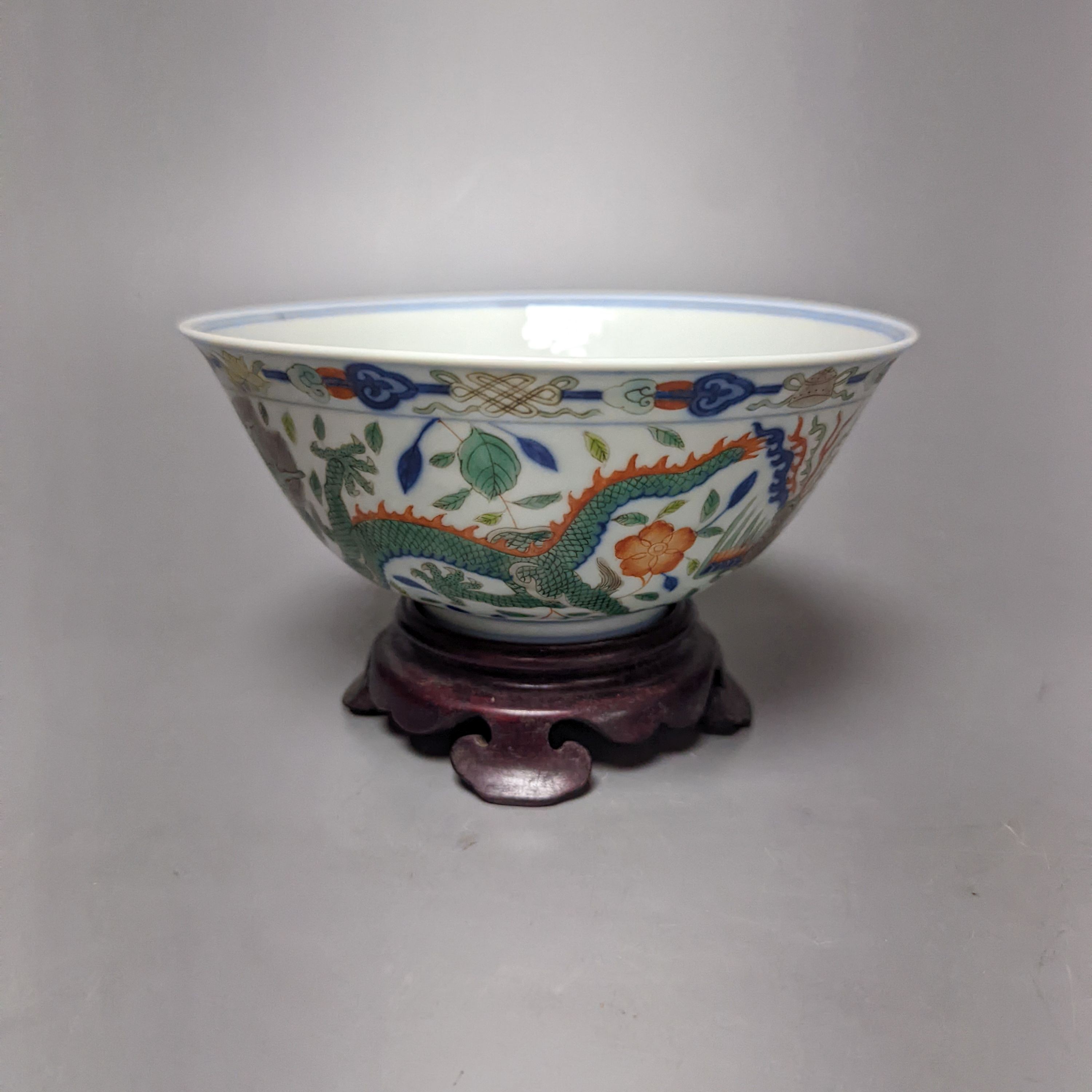 A Wucai bowl, dragon and flamingo pearl decoration, Jiaqing mark, on wood stand. 16cm diameter